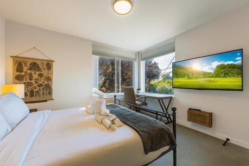 a bedroom with a bed and a large window at Perch - Wallingford Comfort in Seattle