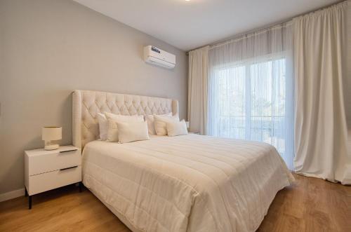 a bedroom with a large bed with a large window at Hesperides Gardens D203 in Ktima