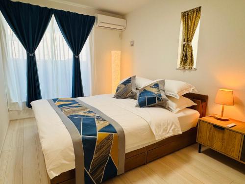 a bedroom with a bed with blue curtains at 大阪りんくん新築Yutori蘭 in Izumi-Sano