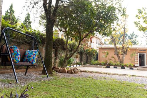a swing in a yard in front of a house at Kara Space BnB in Kampala