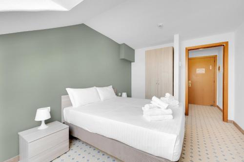 a bedroom with a white bed with towels on it at Mi Casa FRASCHINI in Milan