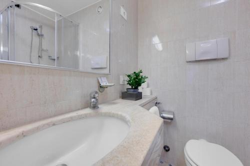 a bathroom with a tub and a toilet and a sink at Mi Casa FRASCHINI in Milan