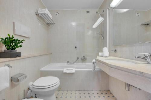 a white bathroom with a toilet and a sink at Mi Casa FRASCHINI in Milan