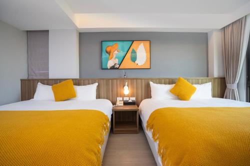 two beds in a hotel room with yellow sheets at 花蓮壽豐 - Twinkle Night 星空說民宿A館 in Zhixue