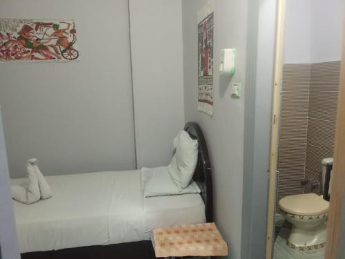 ルクソールにあるBob Marley Peace hotel luxorのトイレとベッドのある小さな白い部屋