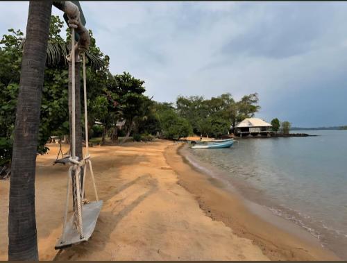 a sandy beach with a boat in the water at Laem Tukkata beach Koh Mak in Ko Mak