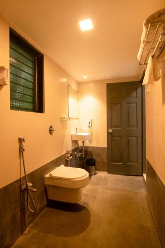 a bathroom with a toilet and a sink at Silvanus Forest Retreat, Alibaug in Alibaug