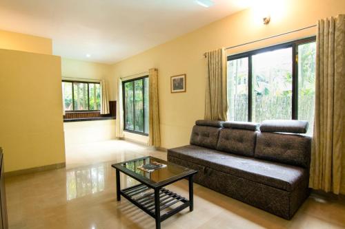 a living room with a couch and a table at Silvanus Forest Retreat, Alibaug in Alibaug