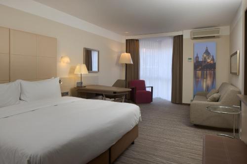a hotel room with a bed and a desk and chair at DoubleTree by Hilton Hannover Schweizerhof in Hannover