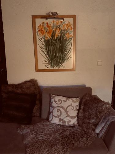 a living room with a couch and a picture of flowers at Mountain house in Palaios Agios Athanasios