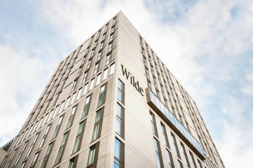a tall white building with the name on it at Wilde Aparthotels Manchester City Centre in Manchester