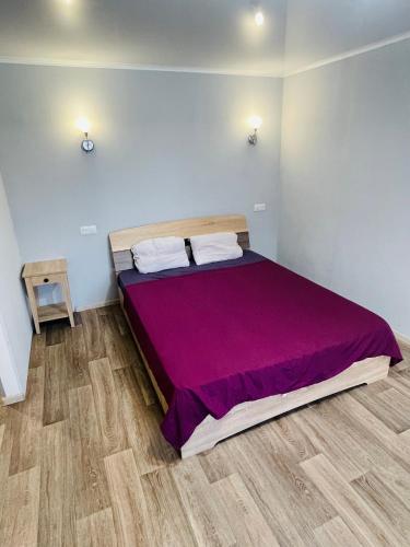 a bedroom with a large bed with a purple bedspread at ApartCenter апартаменты в центре Gagarin mall in Kryvyi Rih