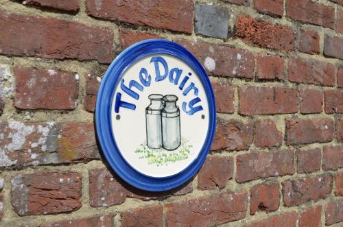 a blue and white sign on a brick wall at Rural Farm Cottage nr Canterbury - logburner, parking, 2bed and 2bath -idyllic setting in Stelling
