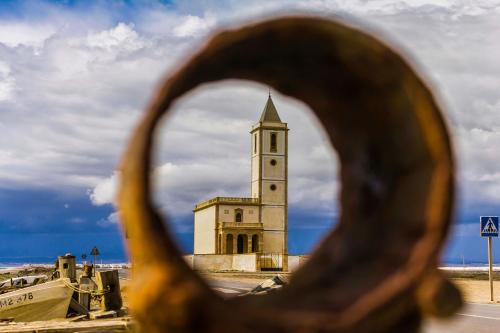 a building with a clock tower in the background at Apartamentos La Calilla Cabo de Gata in El Cabo de Gata