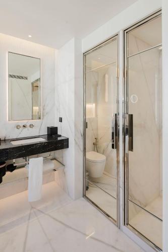 a bathroom with a glass shower and a toilet at Lisbon Chiado Hotel & Spa in Lisbon