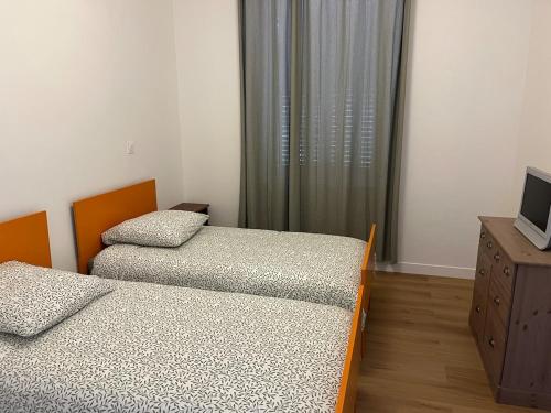 Brassac-les-MinesMaison 8 personnes的一间设有两张床和电视的房间