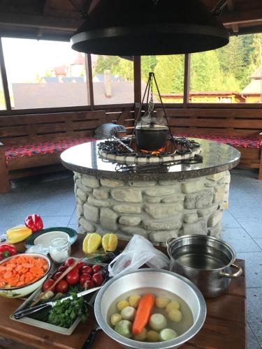 a table topped with bowls of vegetables and a grill at ЕкоСадиба Пан Атаман in Skhidnitsa