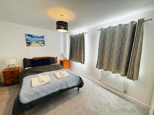Norton FitzwarrenにあるCozy Stays Tauntonのベッドとタオル2枚のある寝室
