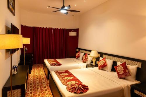 a hotel room with two beds and a ceiling fan at LÂM NGUYỄN 2 hotel in Phu Quoc