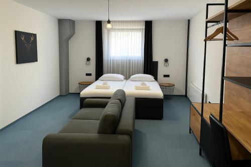 a hotel room with a bed and a couch at Arena Bakarni in Brčko