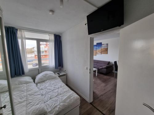 a small bedroom with a bed and a window at Frische Brise FeWo 02 09 in Sahlenburg