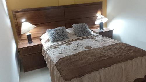 a bedroom with a large bed with two lamps at Tesoro Palmas Resort in Mazatlán