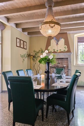 a dining room with a table and chairs and a chandelier at Le Ali Del Frassino in Peschiera del Garda