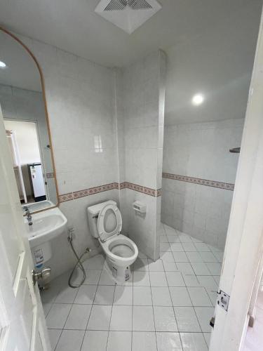 a bathroom with a toilet and a sink at ปากช่องอพาร์ทเม้นท์ in Pak Chong