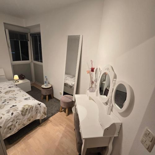 a bedroom with a bed and a table and mirror at EBE-Connect in Ebersberg