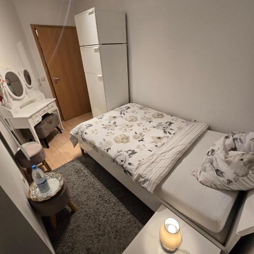 a small bedroom with a bed and a desk at EBE-Connect in Ebersberg