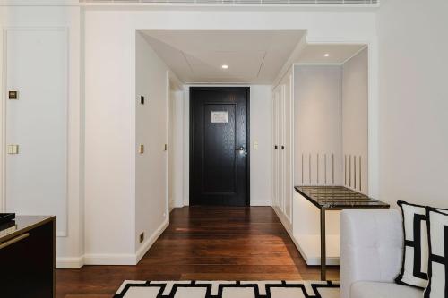 a hallway with a black door and a white wall at Lisbon Chiado Hotel & Spa in Lisbon