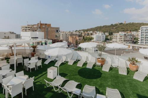 a group of white chairs and umbrellas on a roof at Gomila Palma Apartments in Palma de Mallorca