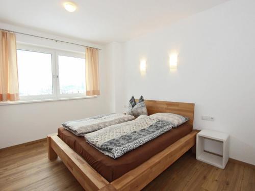 a bedroom with a bed with a wooden frame and a window at Holiday Home Zell am Ziller Ski Lift in Zell am Ziller