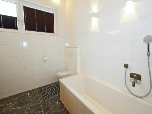a white bathroom with a tub and a toilet at Holiday Home Zell am Ziller Ski Lift in Zell am Ziller