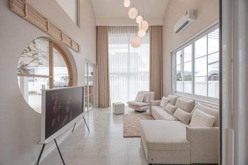 a living room with a tv and a couch at White Wood Family Villa, 5 Kingbeds, 12 mins airport in Chiang Mai