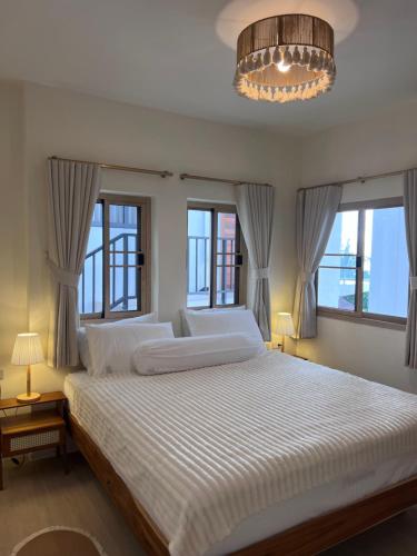 a bedroom with a large bed with windows and a chandelier at v17 Villa Rivine in Ko Phangan