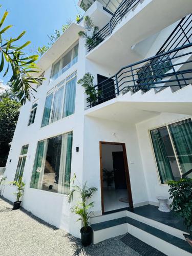a white building with a door and some plants at Samriddhi Homestay in Trivandrum