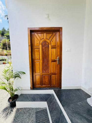 a wooden door with a potted plant in front of it at Samriddhi Homestay in Trivandrum