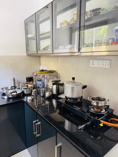 a kitchen with a stove with pots and pans at Samriddhi Homestay in Trivandrum