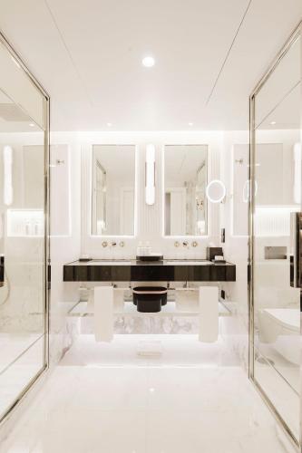a white bathroom with a sink and mirrors at Lisbon Chiado Hotel & Spa in Lisbon