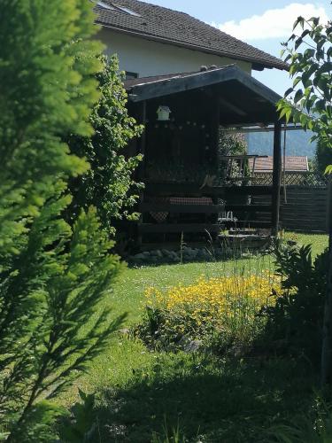 a house with a yard with flowers in the grass at Hotel Alp Inn - Chiemgaukarte inclusive in Ruhpolding