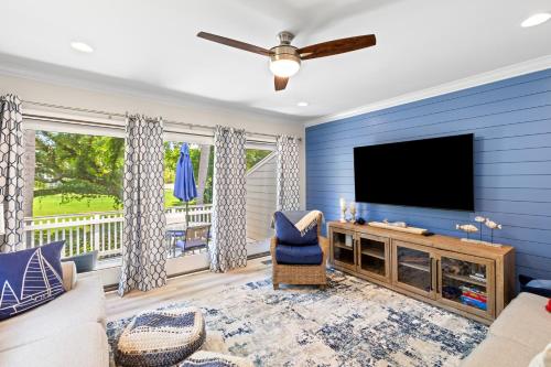 a living room with blue walls and a flat screen tv at Fairway Dunes 12 - Beach & Golf Dream in Isle of Palms