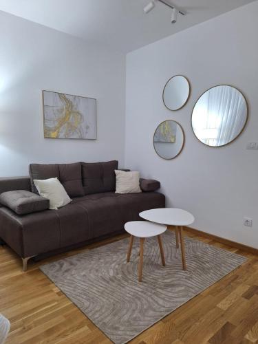 a living room with a couch and two tables at Sokolis Apartman in Kragujevac
