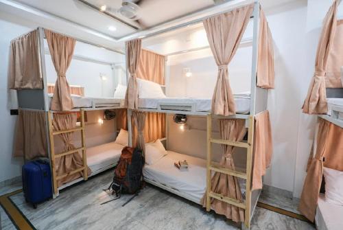 a room with three bunk beds and a suitcase at 3 Raahi Varanasi in Varanasi