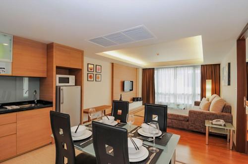 a kitchen and living room with a table and chairs at Olive Hotel & Residence Bangkok Sukhumvit 101 in Bangkok
