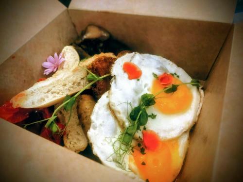 a box with two fried eggs and some bread at The Loft Budapest in Budapest