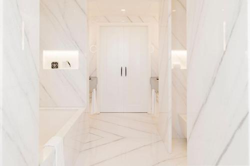 a hallway with white walls and a white door at Lisbon Chiado Hotel & Spa in Lisbon