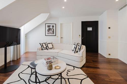 a living room with a white couch and a table at Lisbon Chiado Hotel & Spa in Lisbon