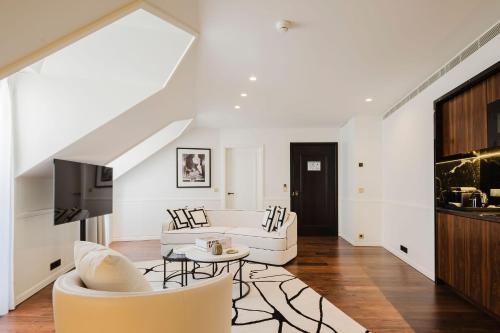 a living room with a white couch and a tv at Lisbon Chiado Hotel & Spa in Lisbon