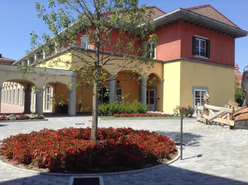 a large building with a tree in a courtyard at Gardaland Adventure Hotel in Castelnuovo del Garda